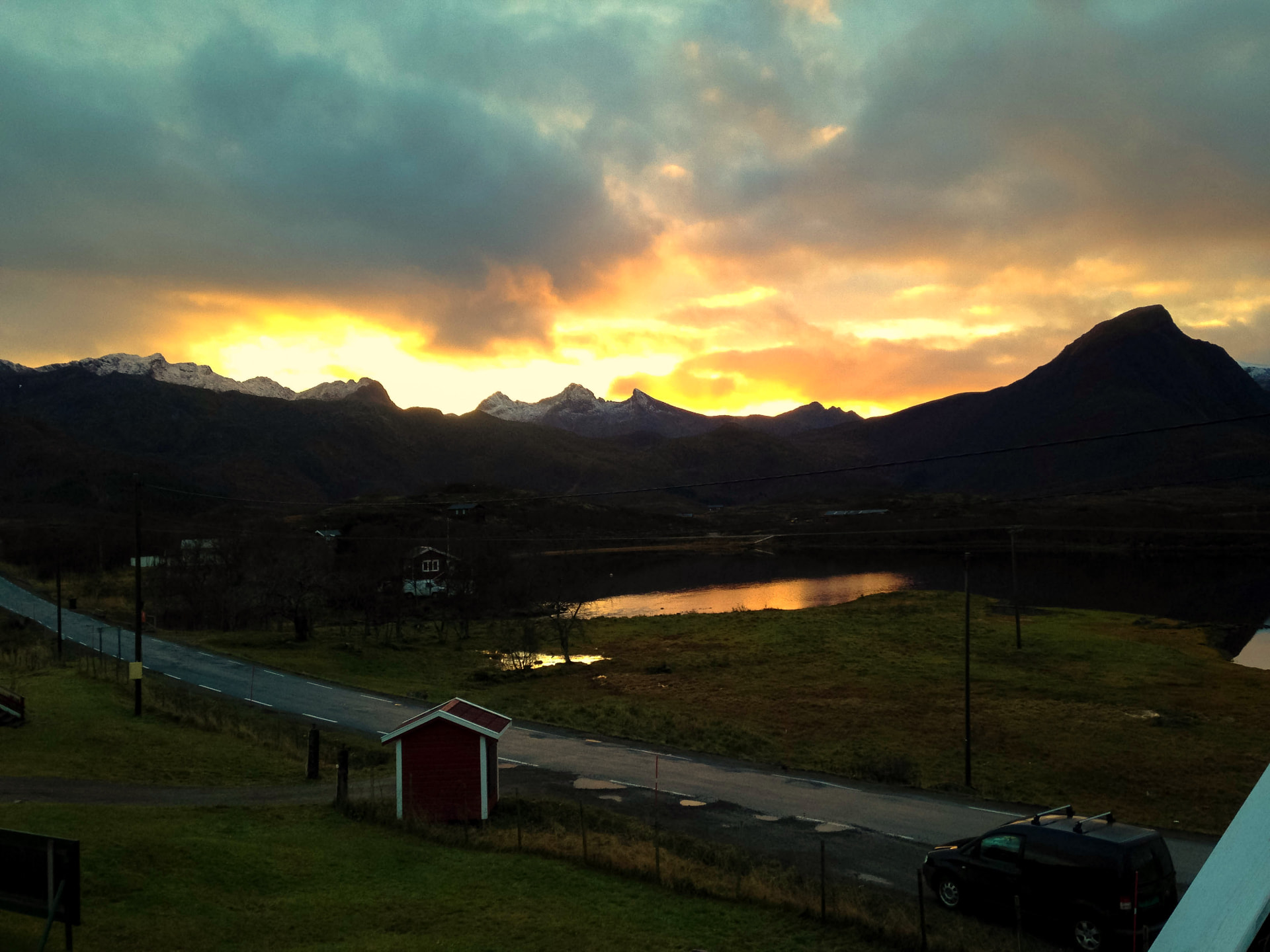 Solnedgang over fjell og vann ved Livland i Lofoten