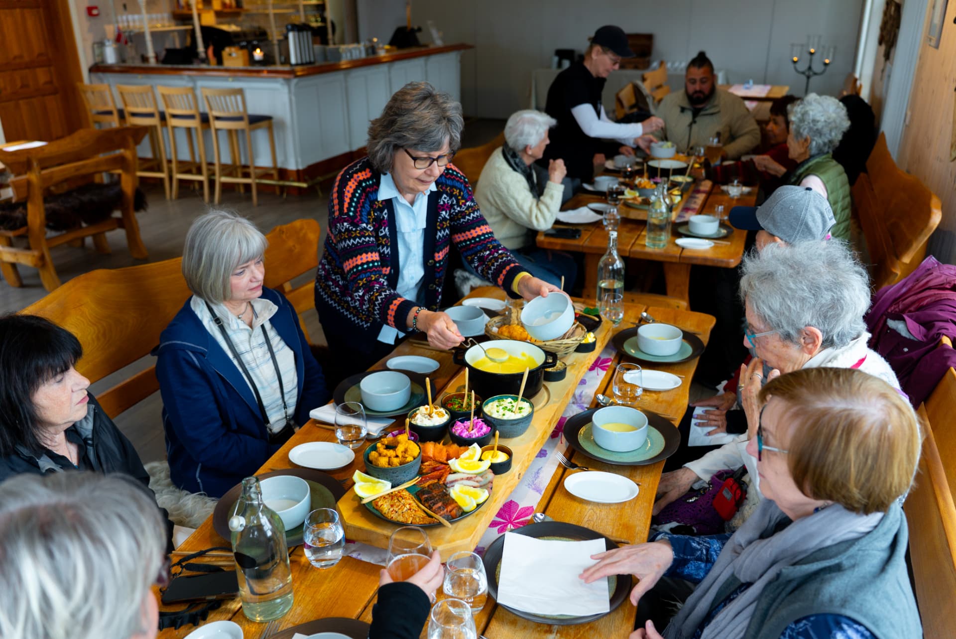 Servering av fat til gjester rundt langbordet på Livland